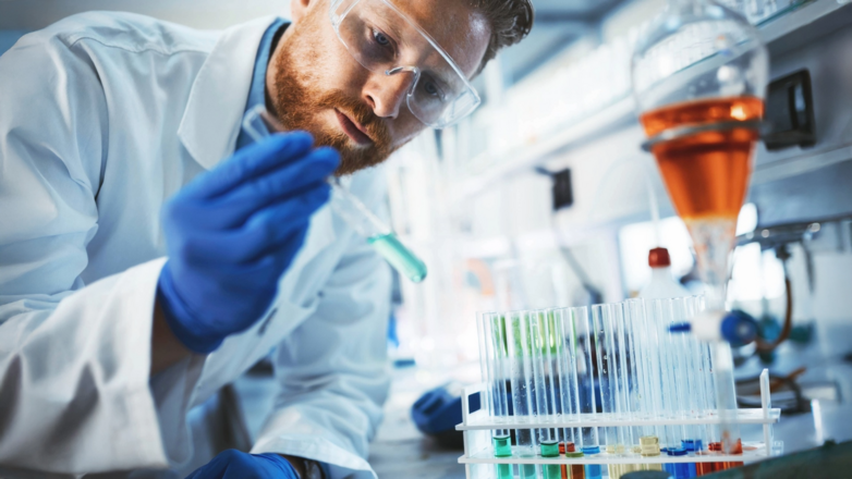 Wissenschaftler mit Schutzbrille und Handschuhen arbeitet mit Reagenzgläsern in einem Labor.